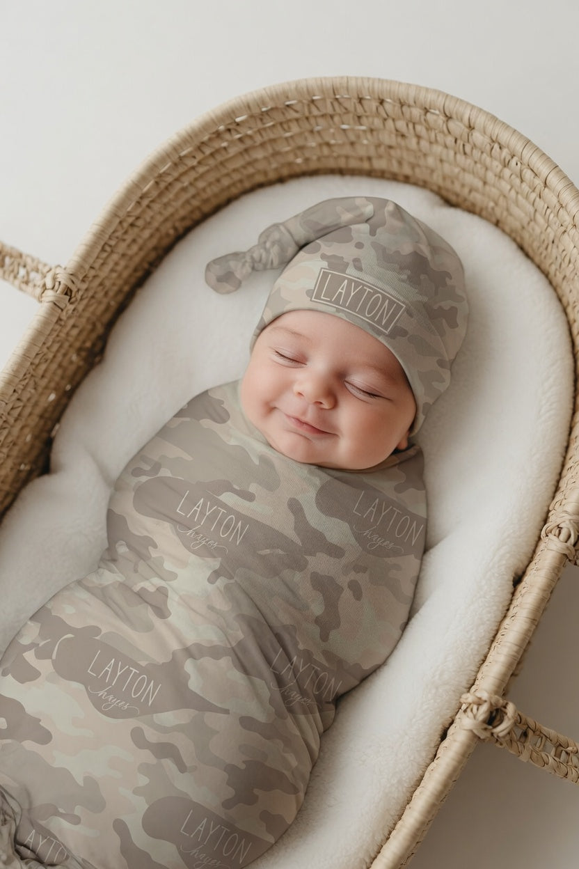 Newborn baby wrapped in personalized sand camo swaddle and matching hat with custom name
