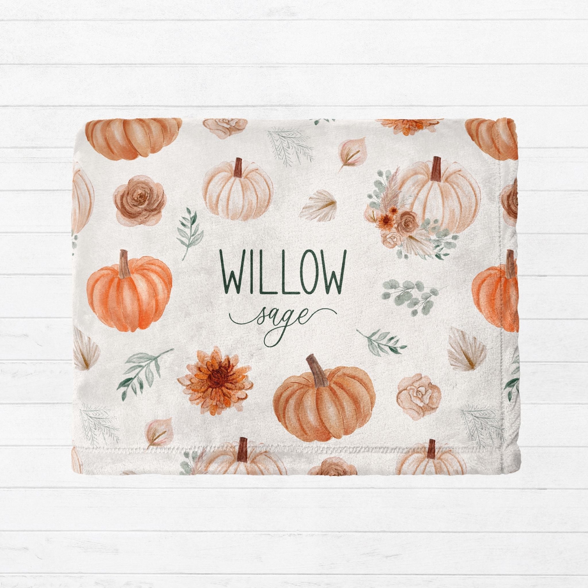 Personalized fall pumpkin minky blanket folded showing watercolor pumpkin floral design with custom name Willow Sage from Twinklette